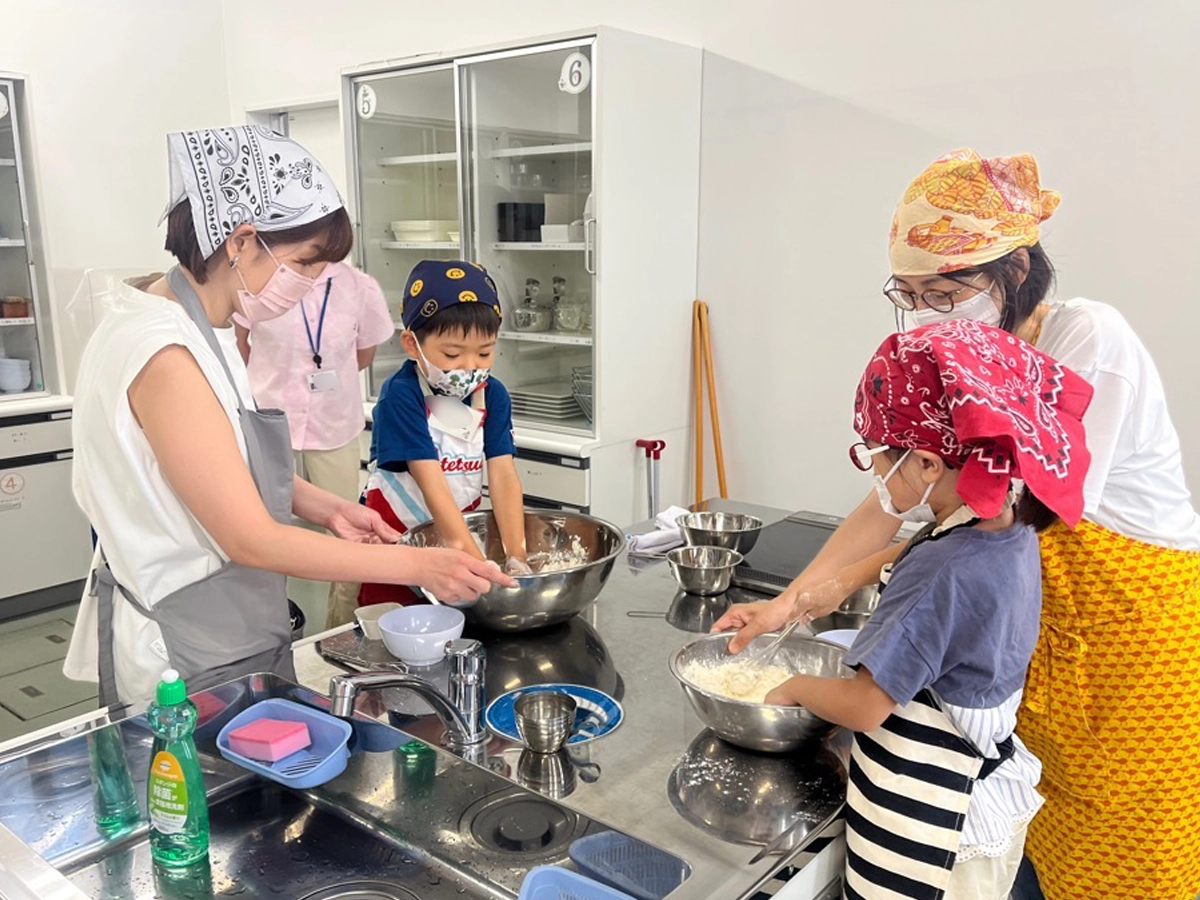市と連携した親子食育教室で、調理実習をする親子